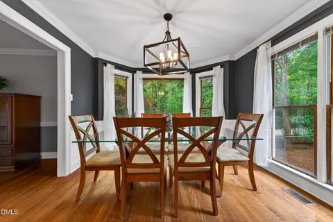 a view of a dining room with furniture wooden floor and chandelier