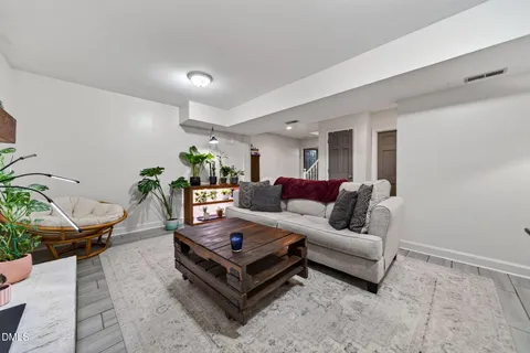 a living room with furniture a flat screen tv and a large window