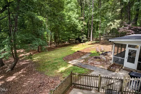 a view of a yard with plants and trees