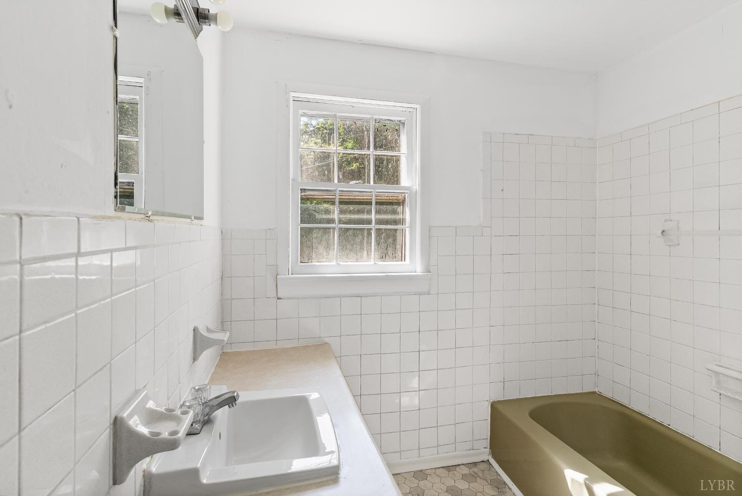 4970 Reedy Spring Road Spout Spring, VA 24593 - Photo 13 of 28 a bathroom with a sink a window and a bathtub