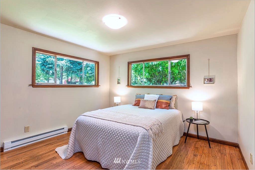 19102 Ridge Road Southwest Vashon, WA 98070 - Photo 11 of 29 a bedroom with a bed and a wooden floor