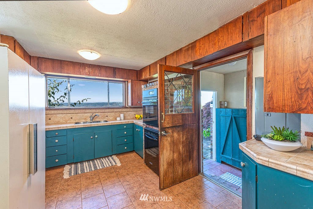 19102 Ridge Road Southwest Vashon, WA 98070 - Photo 15 of 29 a kitchen with kitchen island a counter top space a sink and cabinets