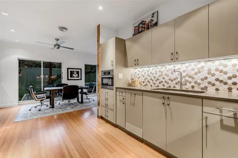 a kitchen with granite countertop sink cabinets and wooden floor