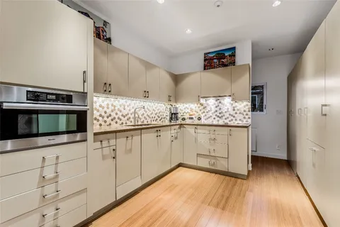 a kitchen with stainless steel appliances a stove and white cabinets