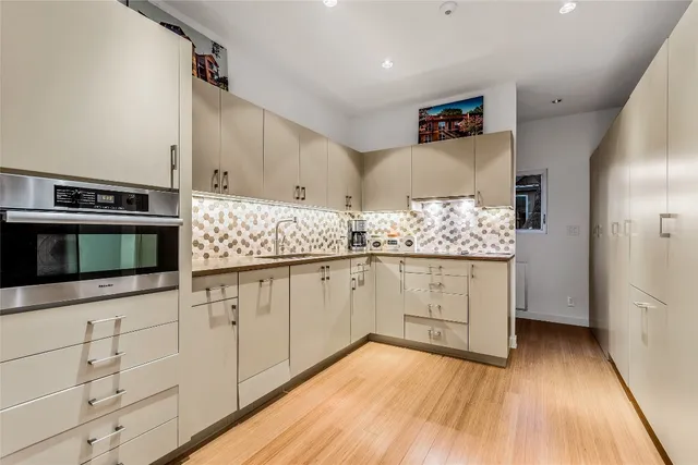 a kitchen with stainless steel appliances a stove and white cabinets
