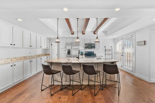 a spacious bedroom with a bed and wooden floor