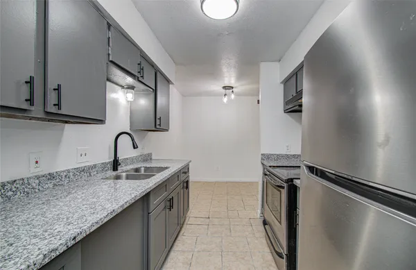 a kitchen with granite countertop a sink and stainless steel appliances
