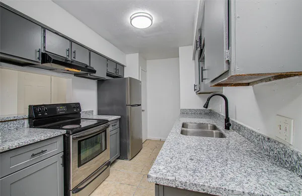 a kitchen with granite countertop a sink stainless steel appliances and cabinets