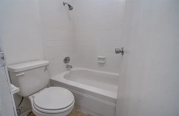 a white toilet and tub sitting next to a bathroom sink