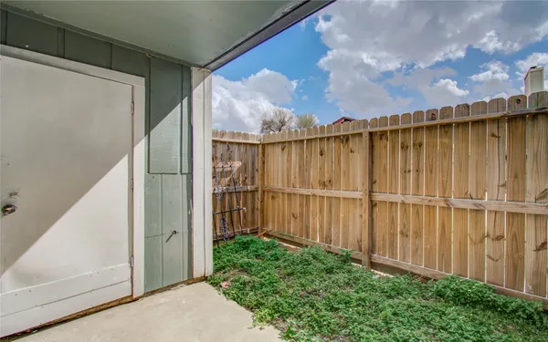a view of a small space with wooden fence