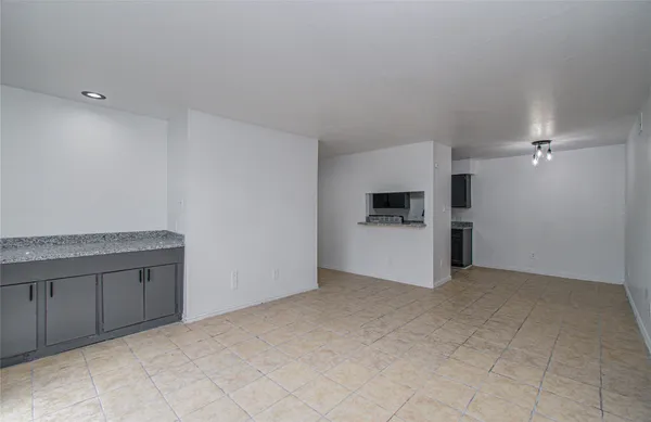 an empty room with kitchen sink and refrigerator