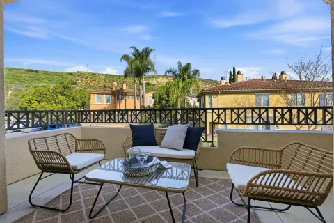 a balcony with furniture and a floor to ceiling window