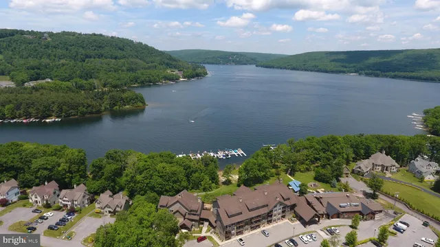 an aerial view of a house with a garden and lake view