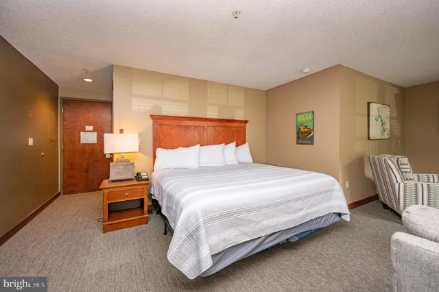 a bedroom with a bed and painting on the wall