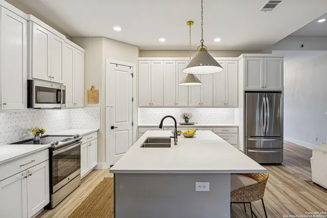 a kitchen with kitchen island a sink appliances and cabinets