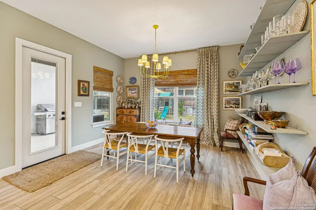 a dining room with furniture a chandelier and wooden floor