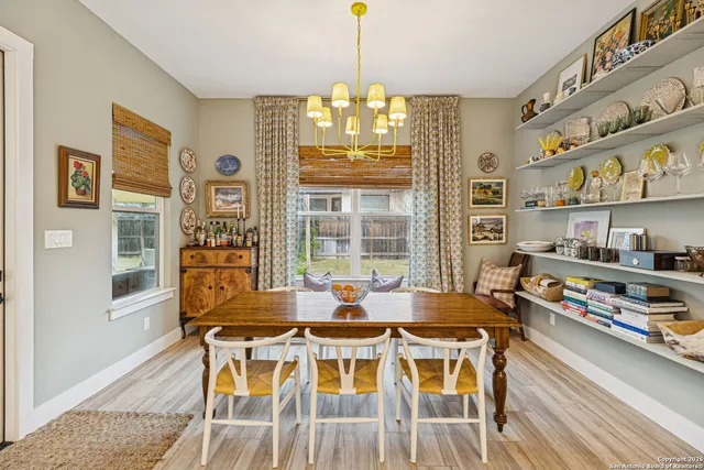 a view of a dining room with furniture a chandelier and wooden floor