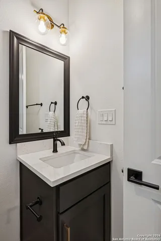 a bathroom with a sink vanity and a mirror