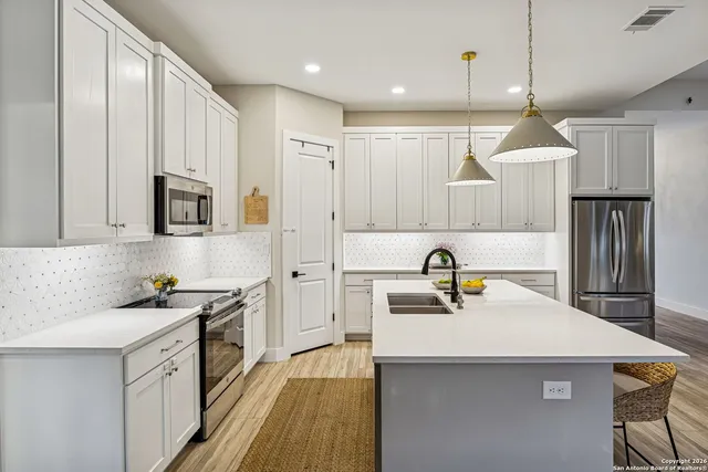 a kitchen with kitchen island a sink stove and refrigerator