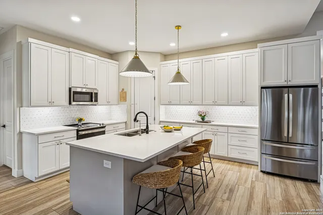 a kitchen with a sink stainless steel appliances and white cabinets