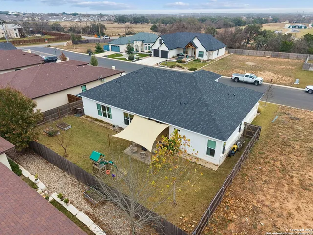 an aerial view of residential houses with outdoor space and ocean view