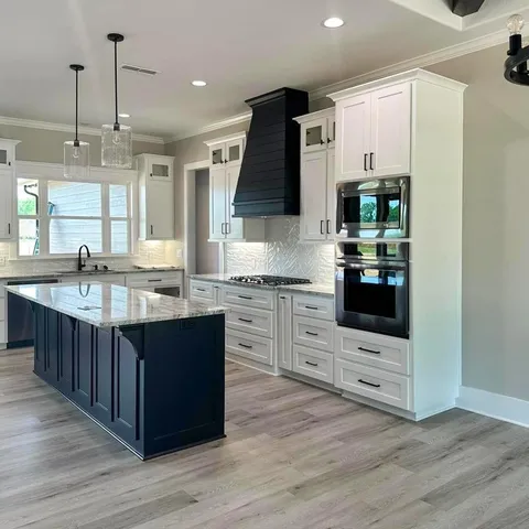 a kitchen with stainless steel appliances kitchen island granite countertop a sink stove and refrigerator