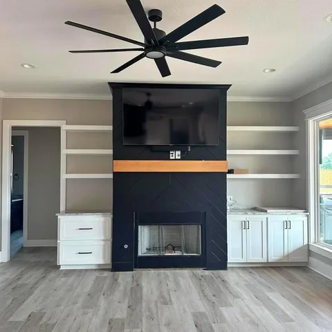 a view of an empty room with wooden floor and a cabinet