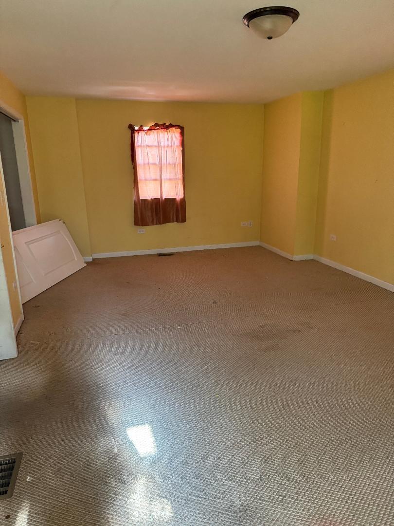 10200 South Rhodes Avenue Chicago, IL 60628 - Photo 10 of 22 an empty room with windows