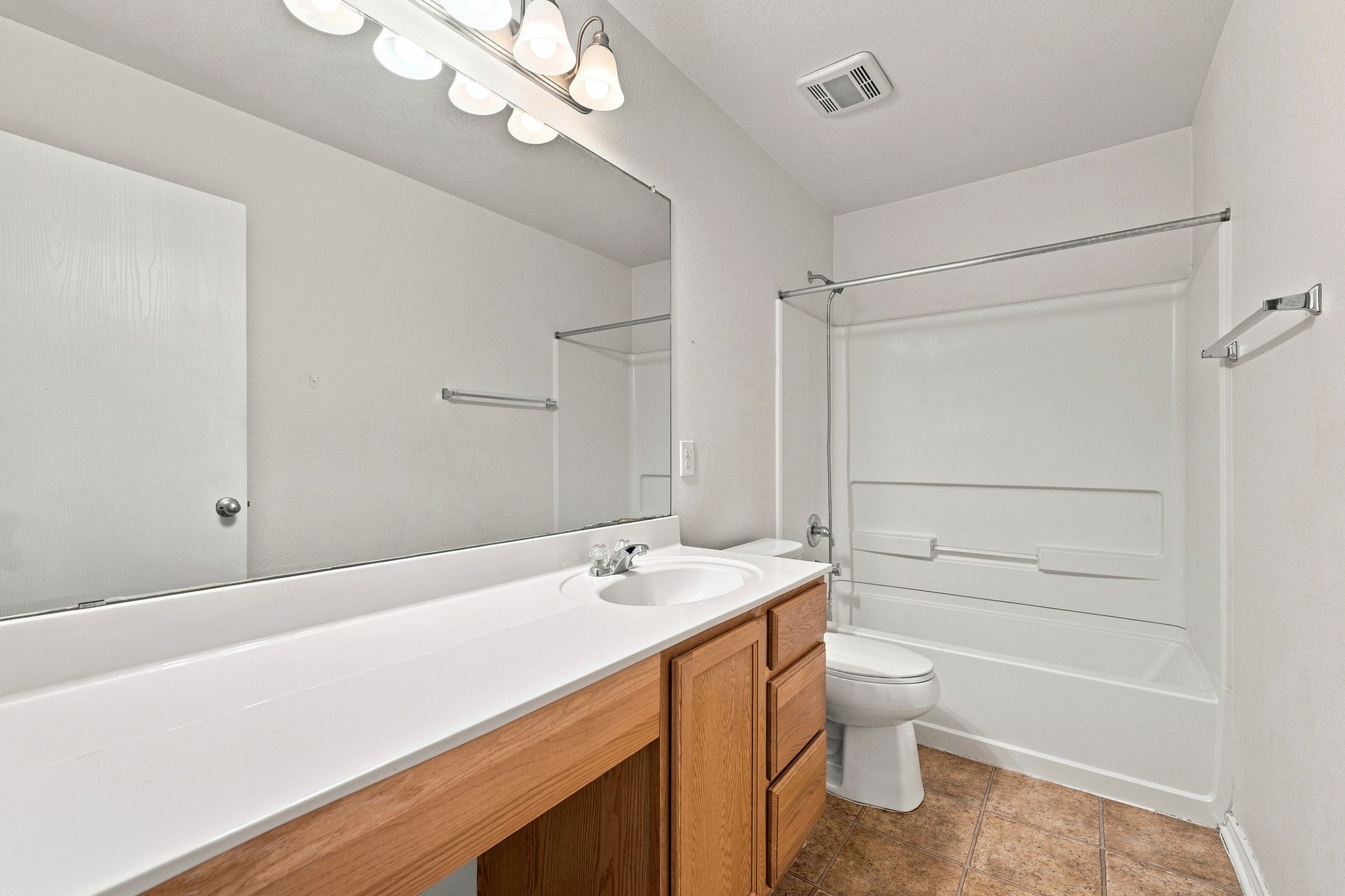 1141 Renaissance Trail Round Rock, TX 78665 - Photo 10 of 21 Functional full bathroom features a wood vanity, large mirror, and tiled flooring.