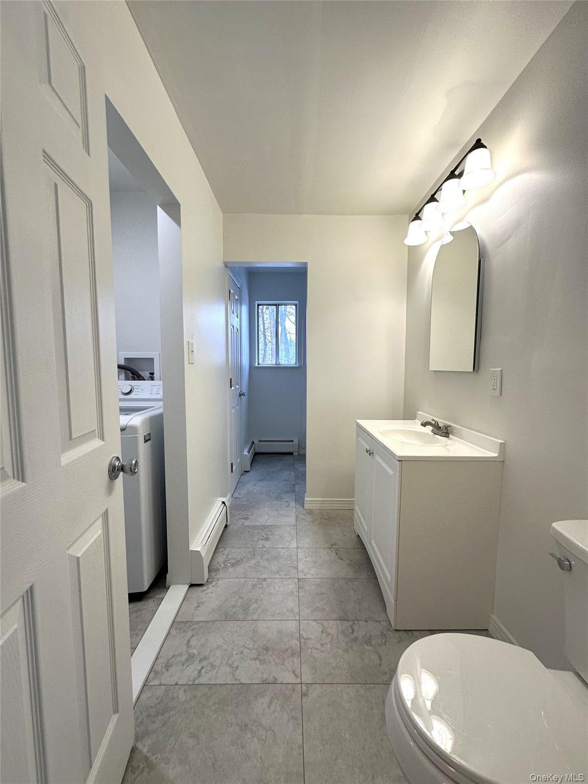 2740 South Road, Unit B7 Poughkeepsie, NY 12601 - Photo 9 of 16 Full bath with laundry room. Freshly painted, new toilet, new vanity, new light fixtures, new flooring, newly tiled bath area around tub.