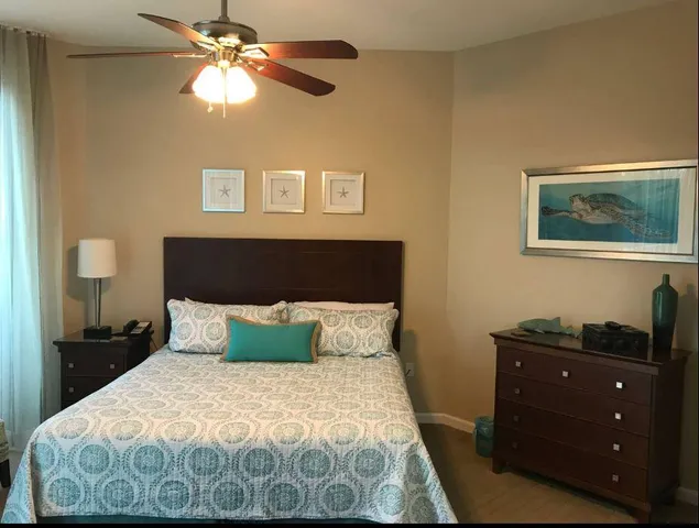a bedroom with a bed and a lamp on dresser