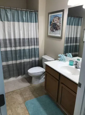 a bathroom with a sink a toilet a mirror and shower