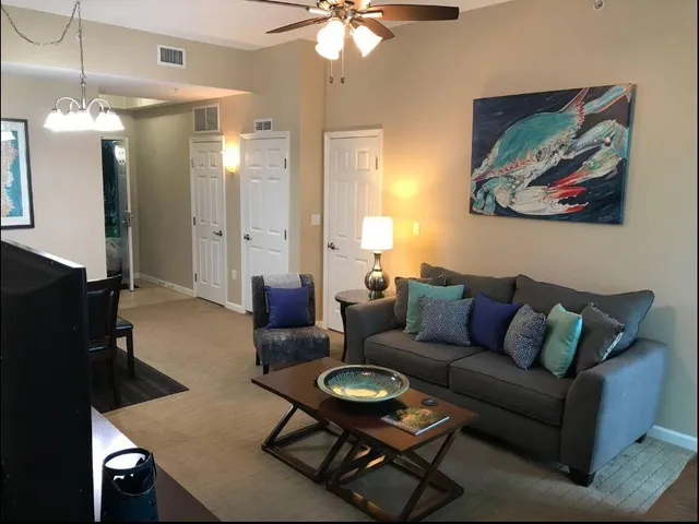 a living room with furniture a chandelier a mirror and a window