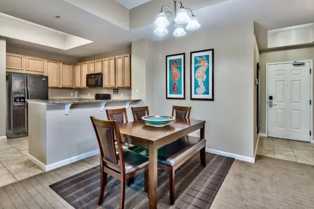 a view of a dining room with furniture a chandelier and wooden floor