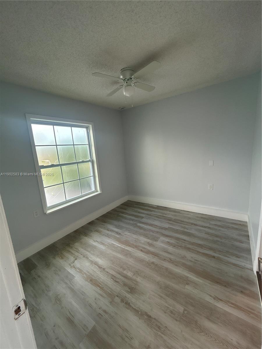 250 Southwest Airview Avenue, Unit B Port St. Lucie, FL 34984 - Photo 3 of 5 wooden floor in an empty room with a window