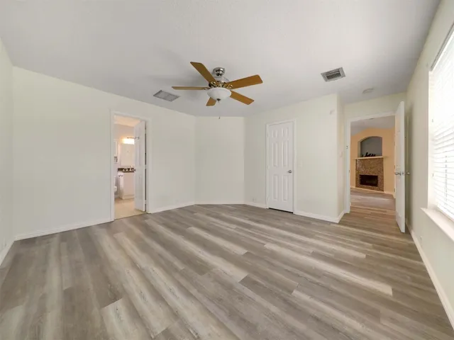 a bathroom with a granite countertop sink a toilet a mirror and a window
