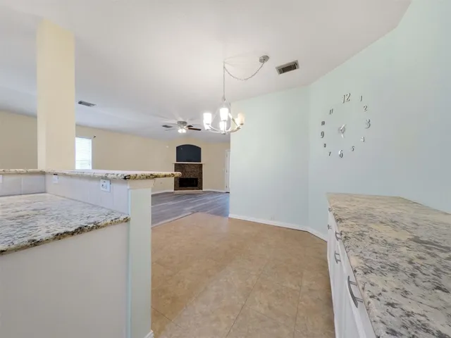 a view of a kitchen with a sink stainless steel appliances furniture and a chandelier