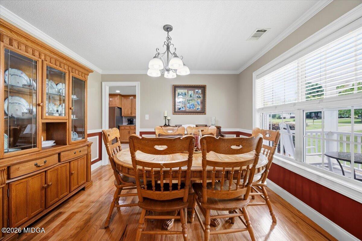 557 Aarons Circle Gray, GA 31032 - Photo 15 of 36 a view of a dining room with furniture a chandelier and wooden floor