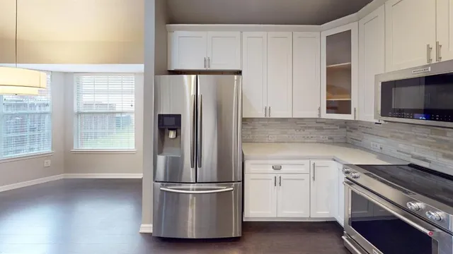 a kitchen with a refrigerator and a stove top oven
