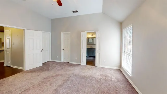 an empty room with closet and windows