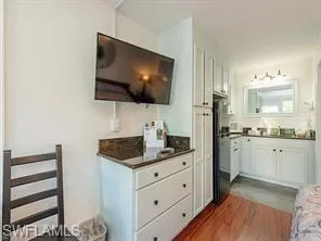 a living room with white cabinets and a flat screen tv