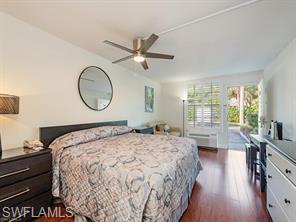 2555 9th Street North, Unit 109 Naples, FL 34103 - Photo 3 of 6 a bedroom with a bed and wooden floor