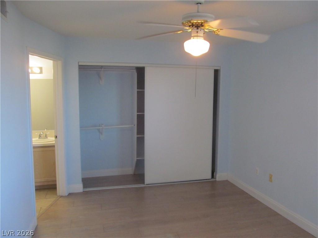 7950 West Flamingo Road, Unit 2048 Las Vegas, NV 89147 - Photo 16 of 24 A well-lit bedroom features durable laminate flooring and a ceiling fan for comfort.