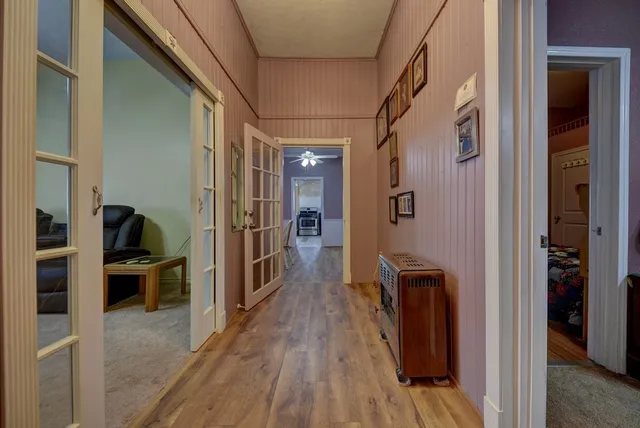 a view of a hallway with wooden floor and windows