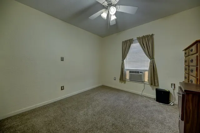 en empty room with windows and fireplace