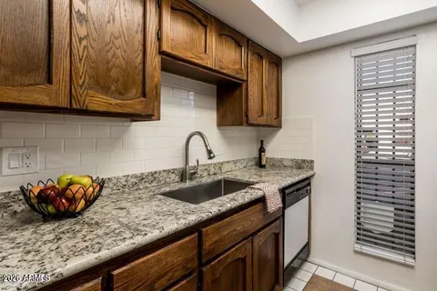 a kitchen with stainless steel appliances granite countertop a sink a stove and cabinets