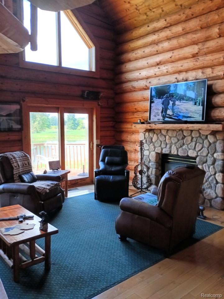 10374 Wilson Road Otisville, MI 48463 - Photo 49 of 99 Living area with a fireplace, hardwood / wood-style floors, high vaulted ceiling, rustic walls, and wooden ceiling