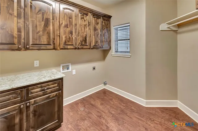 a view of a kitchen with wooden floor and cabinets