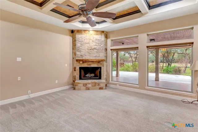 a view of an empty room with a fireplace and a window