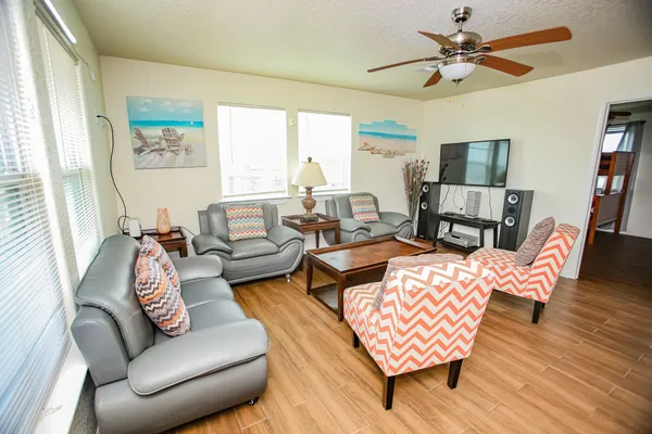 a kitchen with stainless steel appliances a stove a refrigerator a sink dishwasher and a dining table with wooden floor
